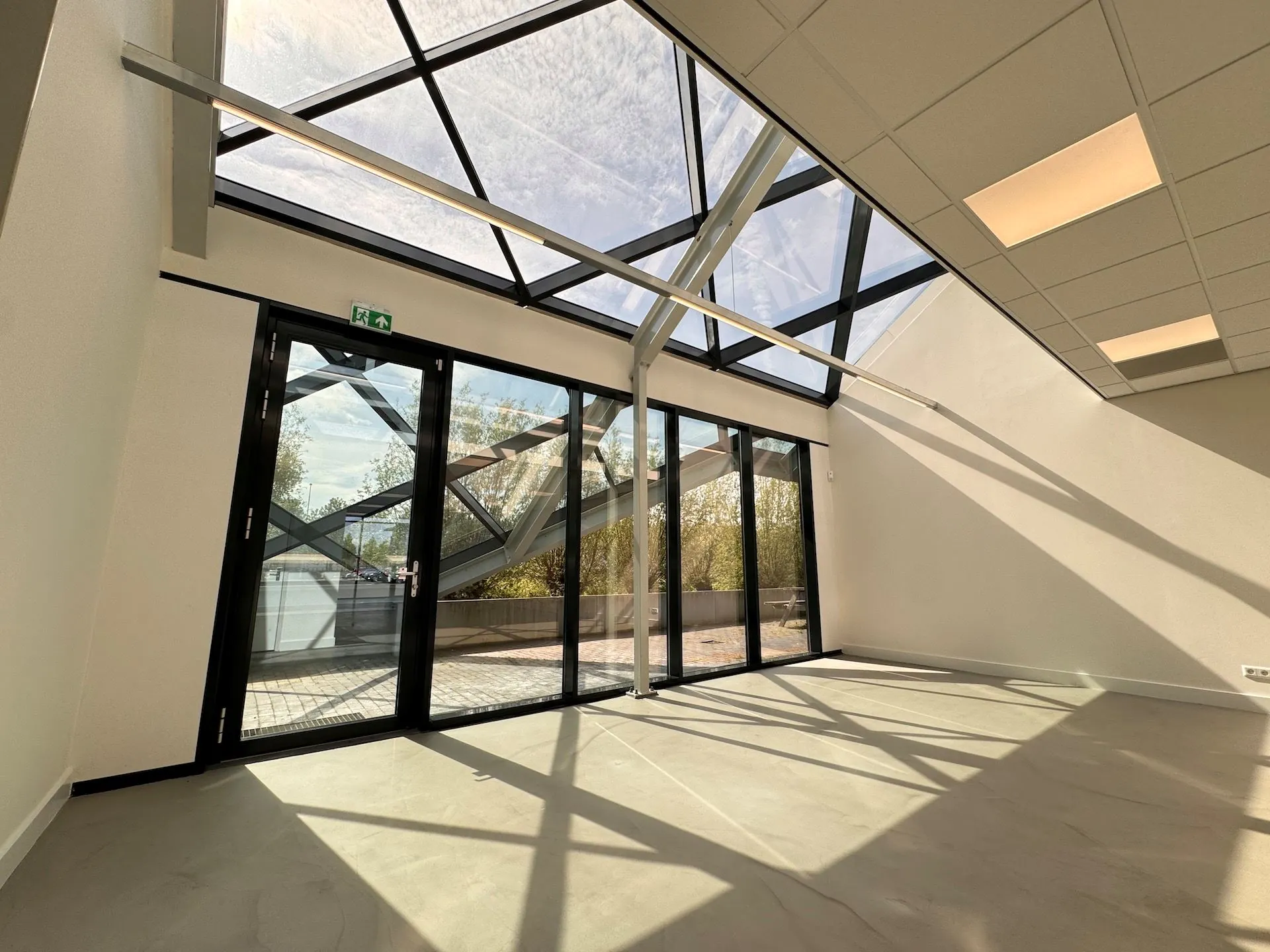 Lichte, moderne ruimte met schuine glazen wand en plafondconstructie in het gebouw Mart Stamhof.